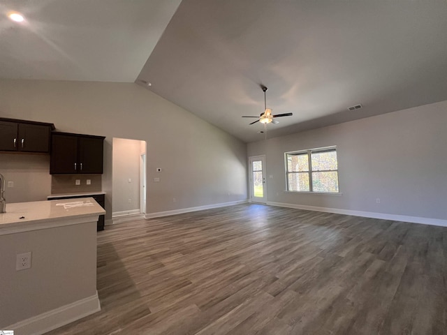 unfurnished living room with a ceiling fan, baseboards, visible vents, and dark wood-type flooring