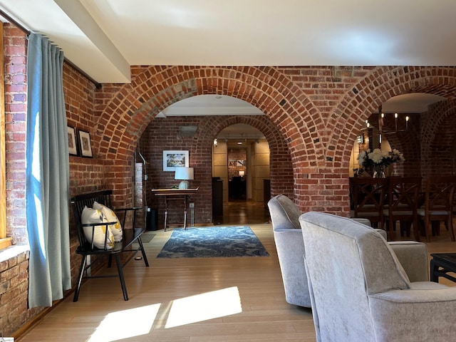 interior space with hardwood / wood-style flooring and brick wall