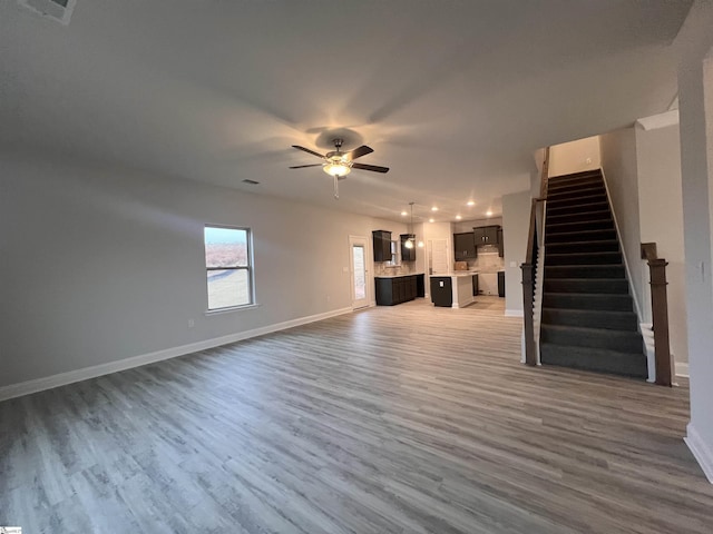 unfurnished living room with wood-type flooring and ceiling fan