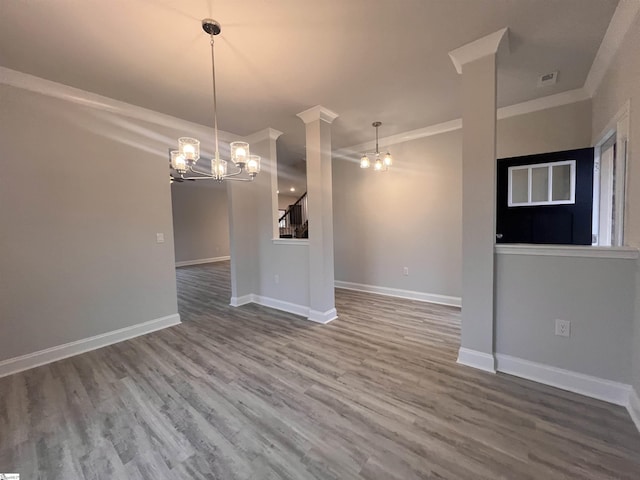 spare room with wood finished floors, stairway, baseboards, and an inviting chandelier