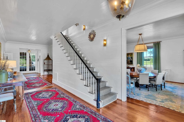 entrance foyer featuring an inviting chandelier, crown molding, and hardwood / wood-style flooring