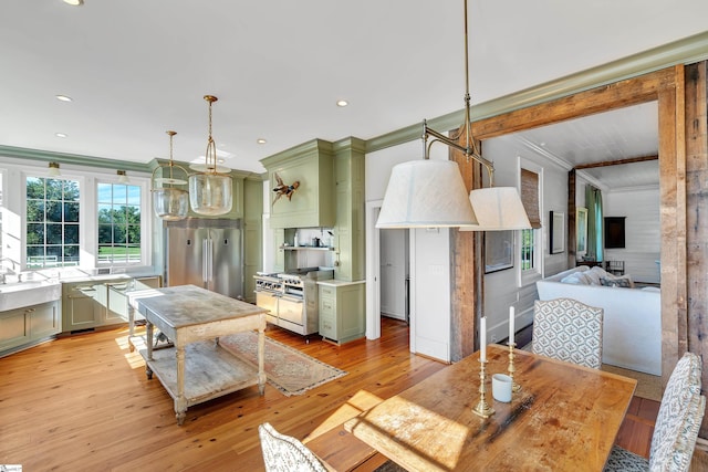 dining area with ornamental molding and light hardwood / wood-style floors