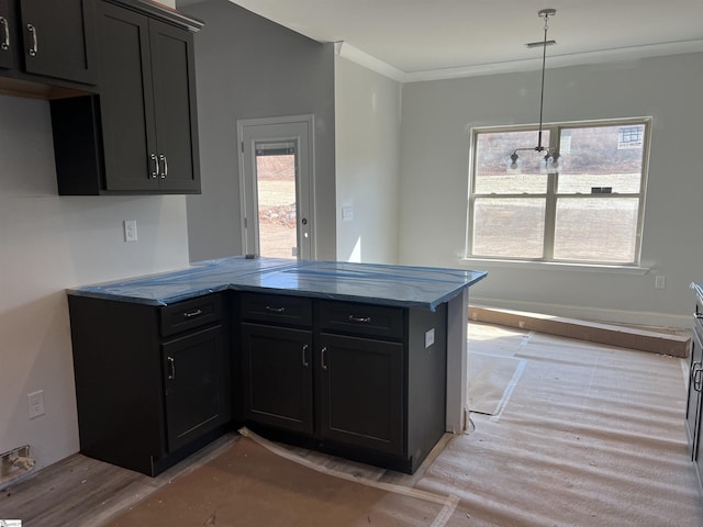 kitchen featuring pendant lighting, crown molding, light hardwood / wood-style flooring, and kitchen peninsula