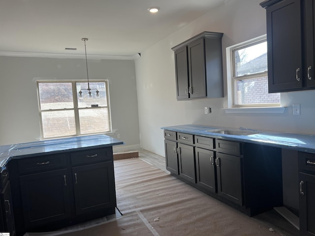 kitchen with crown molding, light wood-type flooring, and decorative light fixtures