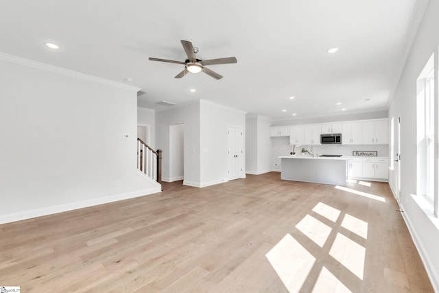 unfurnished living room featuring light hardwood / wood-style floors, ornamental molding, and ceiling fan