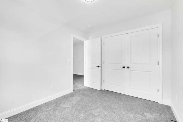 unfurnished bedroom featuring carpet and a closet