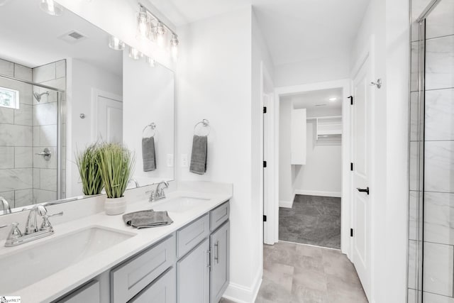 bathroom with a shower with shower door, tile patterned flooring, and dual bowl vanity