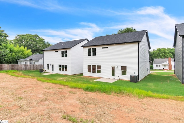 rear view of house with central AC, a patio area, and a yard