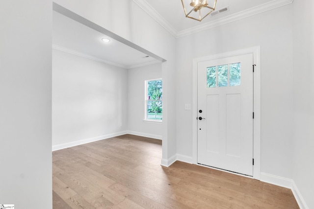 foyer featuring light hardwood / wood-style floors, a notable chandelier, and crown molding