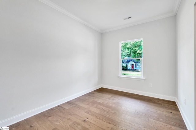 empty room featuring hardwood / wood-style flooring and crown molding