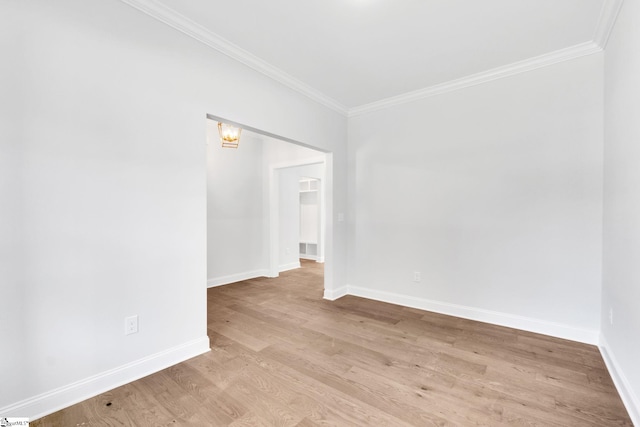 empty room featuring wood-type flooring and ornamental molding