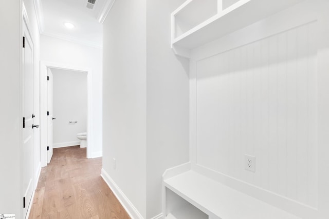 mudroom with light hardwood / wood-style floors and crown molding