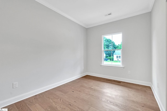 empty room with crown molding and light hardwood / wood-style flooring