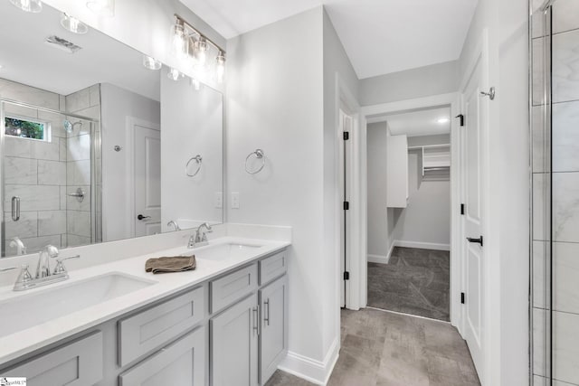 bathroom featuring a shower with door, double vanity, and tile patterned floors