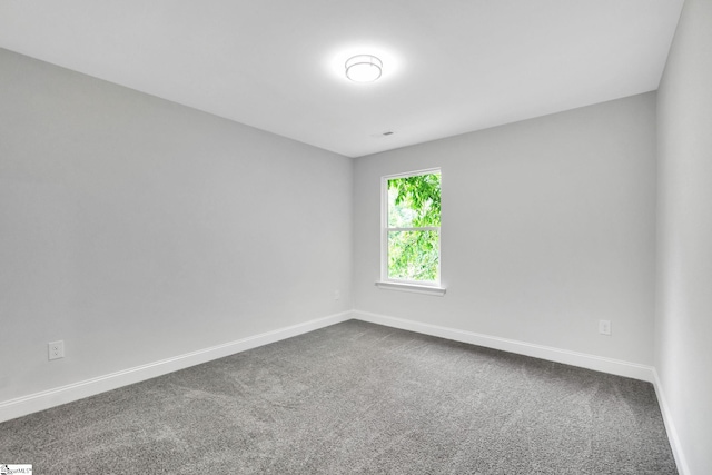 empty room featuring dark colored carpet