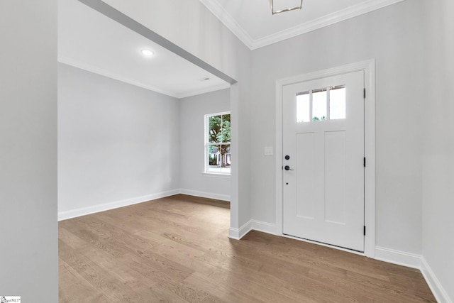 foyer entrance with ornamental molding and light hardwood / wood-style flooring