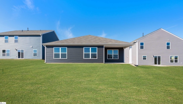 rear view of house featuring a yard