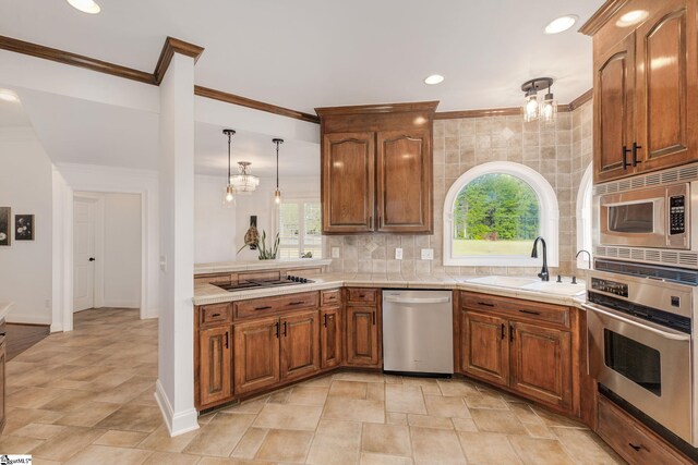 kitchen with sink, appliances with stainless steel finishes, tile countertops, and a wealth of natural light