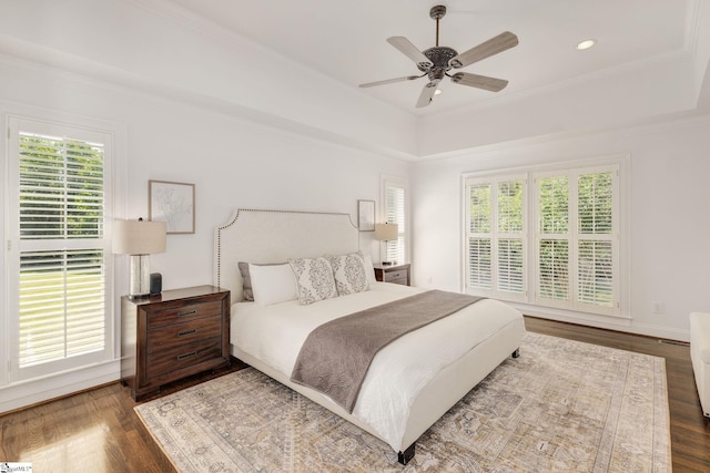 bedroom with hardwood / wood-style flooring, ornamental molding, ceiling fan, and multiple windows