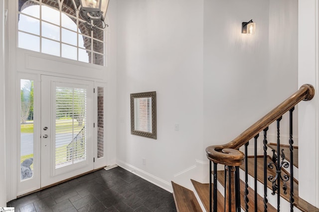 entrance foyer featuring dark hardwood / wood-style floors and a towering ceiling