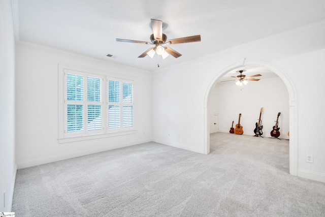 spare room with crown molding, light carpet, and ceiling fan