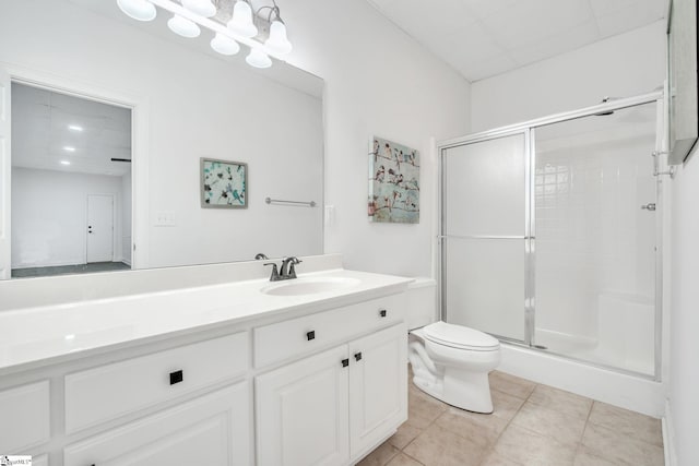 bathroom with tile patterned flooring, vanity, toilet, and a shower with shower door