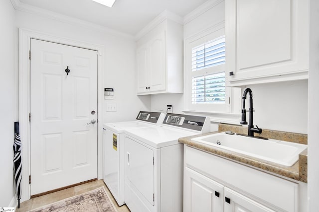 washroom featuring light tile patterned flooring, washing machine and clothes dryer, sink, cabinets, and ornamental molding