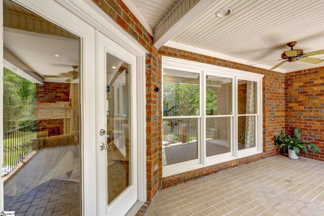 unfurnished sunroom with wood ceiling and ceiling fan