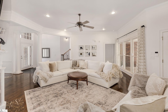 living room with dark hardwood / wood-style flooring, decorative columns, crown molding, and ceiling fan