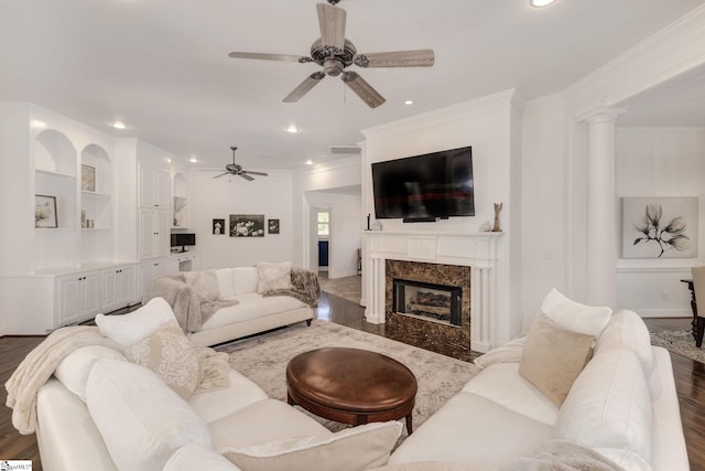 living room with ornate columns, a fireplace, dark hardwood / wood-style flooring, ornamental molding, and ceiling fan