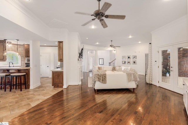 bedroom featuring wood-type flooring, sink, ornamental molding, access to exterior, and french doors