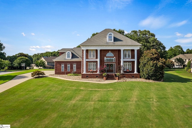 greek revival inspired property featuring a front lawn