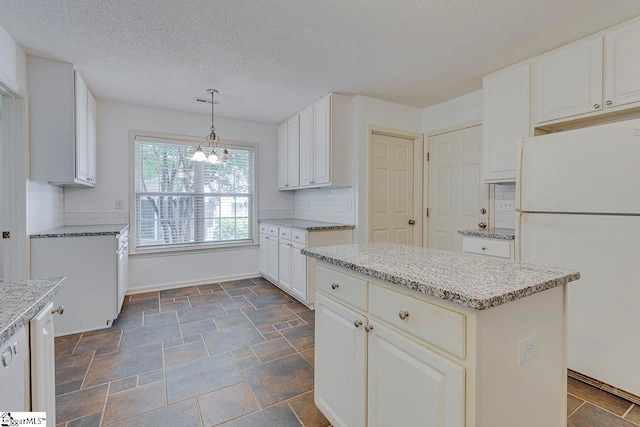 kitchen featuring a center island, white refrigerator, backsplash, and dark tile patterned floors