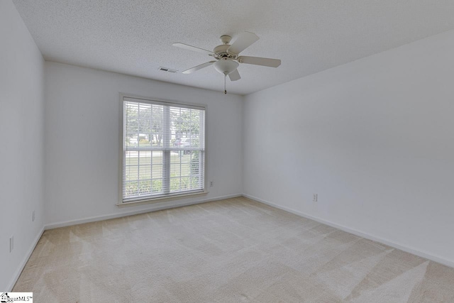 spare room with light carpet and a textured ceiling