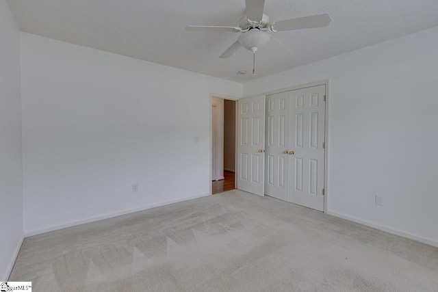 unfurnished bedroom with a closet, a textured ceiling, and light colored carpet