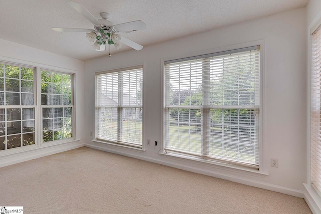 unfurnished sunroom featuring ceiling fan