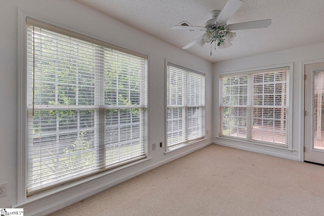 unfurnished sunroom with ceiling fan and plenty of natural light