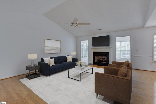 living room with wood-type flooring, high vaulted ceiling, and ceiling fan