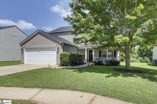 view of front of property with central air condition unit, a garage, and a front yard