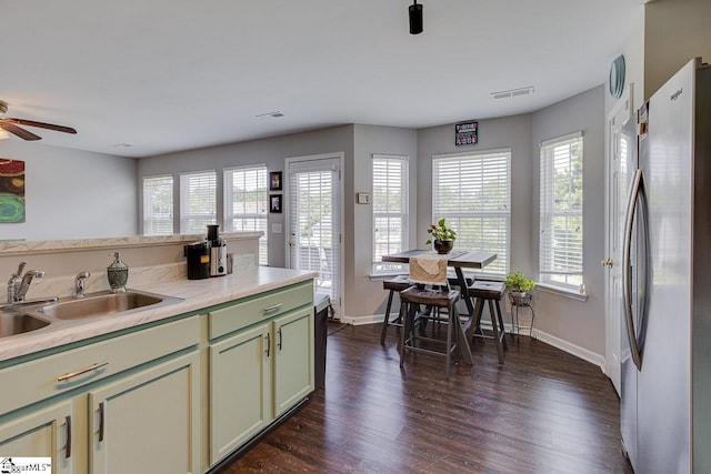 kitchen with visible vents, dark wood finished floors, freestanding refrigerator, light countertops, and a sink