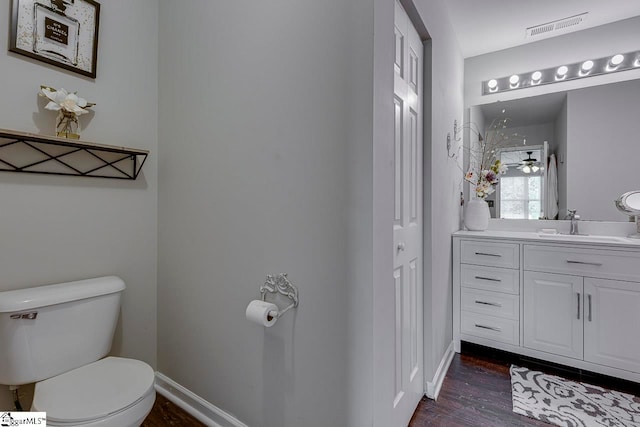 bathroom featuring vanity, toilet, and hardwood / wood-style floors