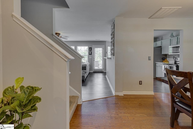 foyer featuring dark wood-type flooring, stairway, and baseboards