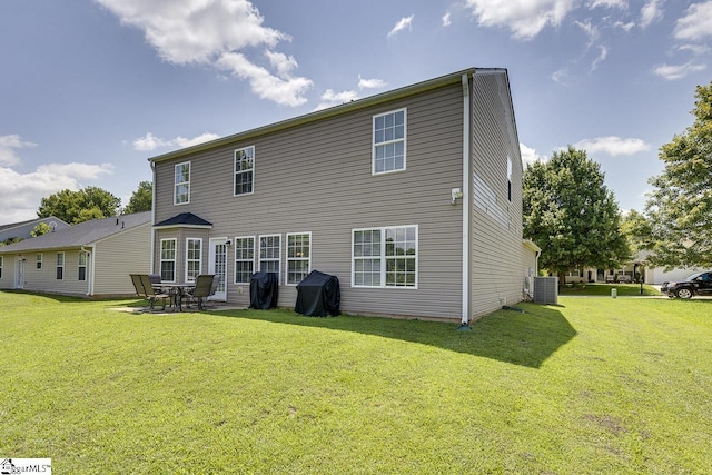 rear view of property with a yard, a patio, and cooling unit