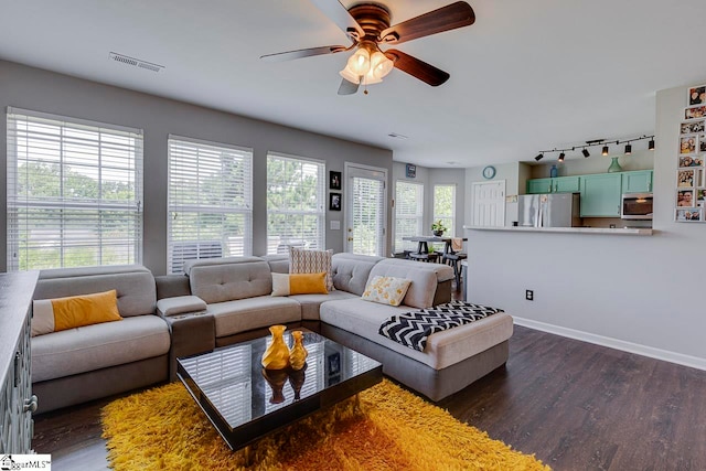 living room featuring dark hardwood / wood-style flooring, ceiling fan, plenty of natural light, and rail lighting