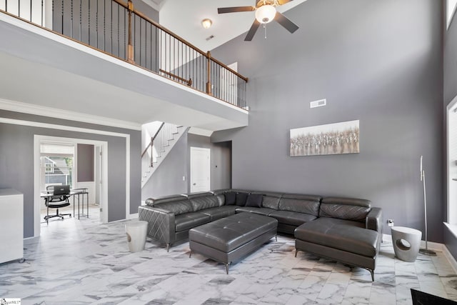 living room featuring ornamental molding, ceiling fan, light tile patterned floors, and a towering ceiling