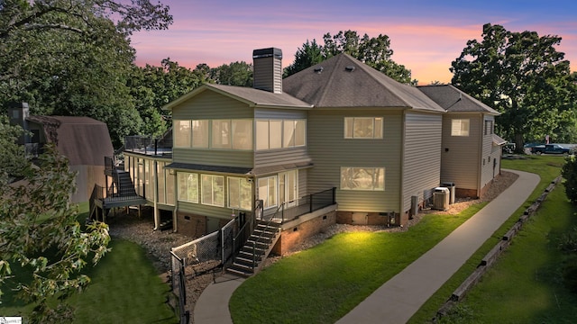 view of front of house with cooling unit, a lawn, and a wooden deck