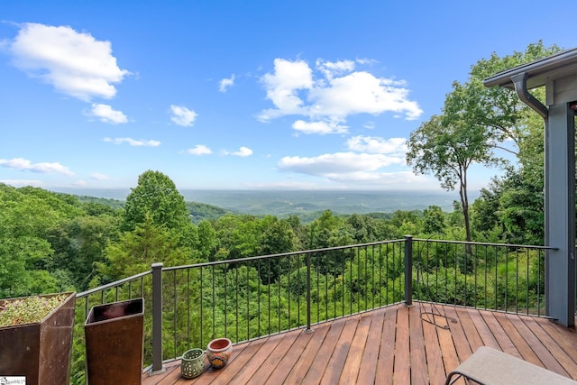 wooden terrace featuring a view of trees