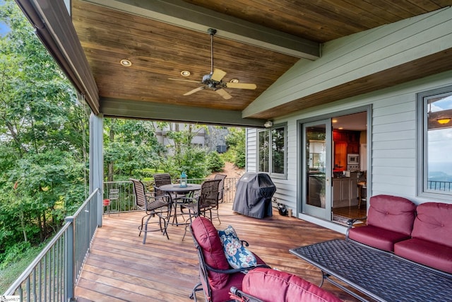 deck with outdoor dining space, ceiling fan, and area for grilling