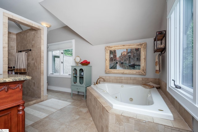 full bathroom featuring lofted ceiling, tile patterned flooring, a tile shower, and a whirlpool tub