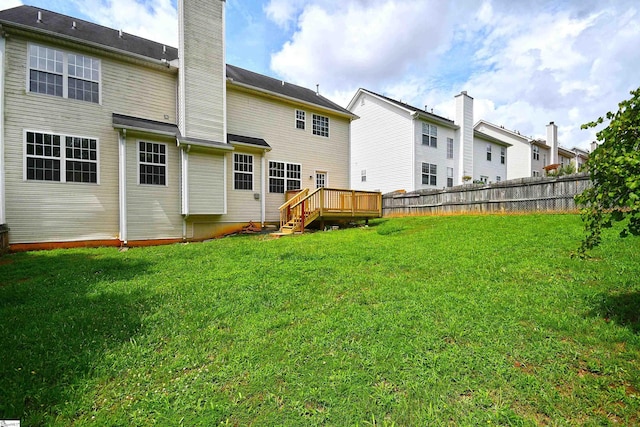 rear view of property with a yard and a deck